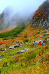 背後に迫る山と歩く人々640×960